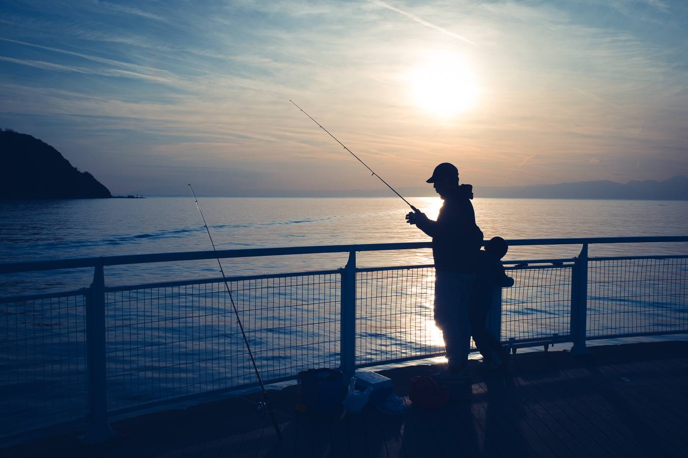 Le soleil se couche, un pêcheur tente d'attraqpper ses derniers poissons dans la mer à Enoshima