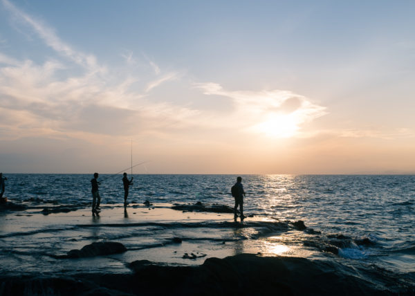 Le soleil se couche sur enoshima et les pecheurs profitent des derniers rayons de soleil