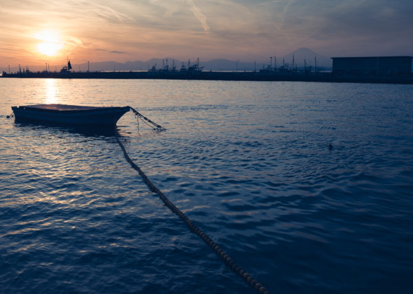 Une barque flotte sur la mer d'Enoshima tandisque le soleil se couche